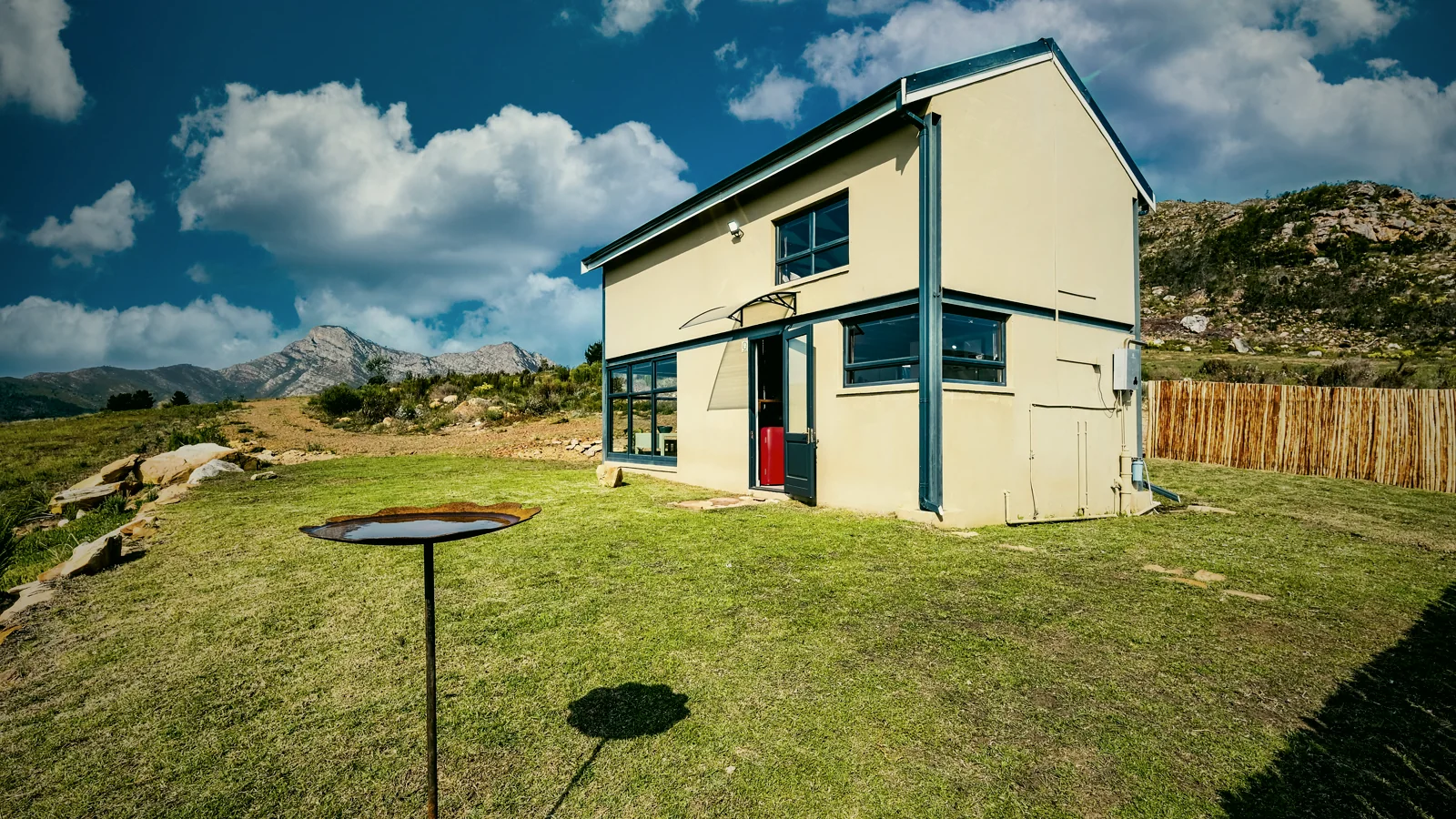 The cream two-storey Shepherd's Rest tiny house and private lawn